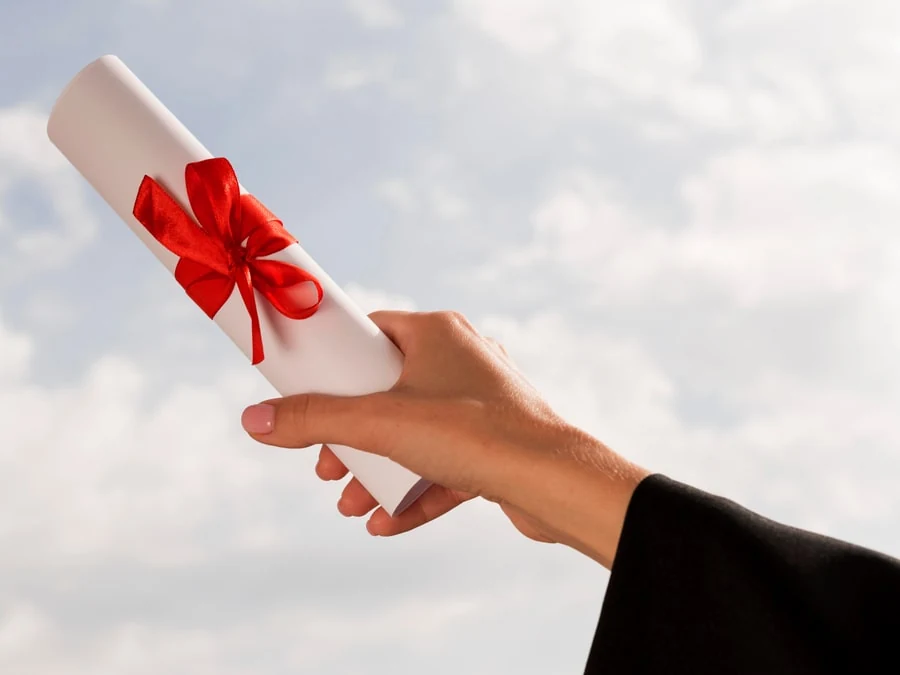 Kırmızı kurdeleyle bağlanmış diploma belgesi